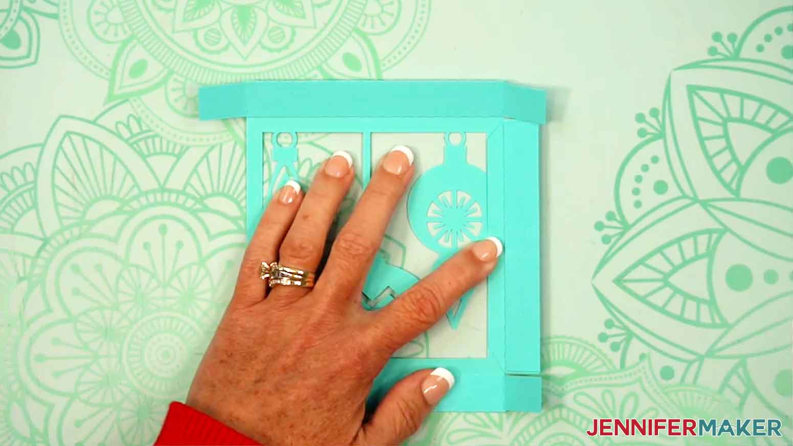 The side pieces are being aligned with the top of the gift box.