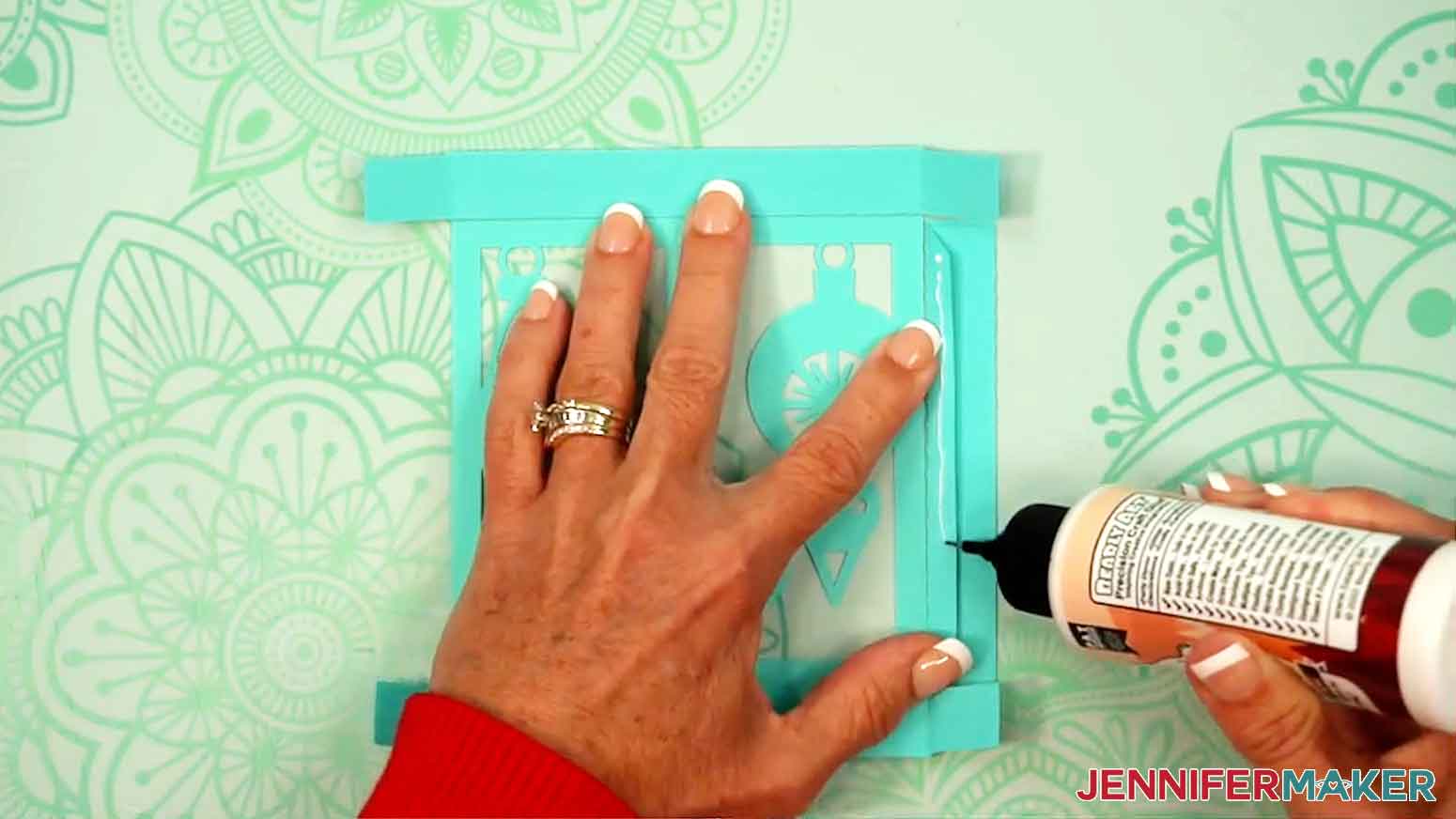 Glue is being applied to the side piece of the top of the lid of the gift box.