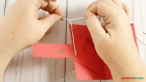 Tying the two ends of embroidery floss together for the easy leather wallet