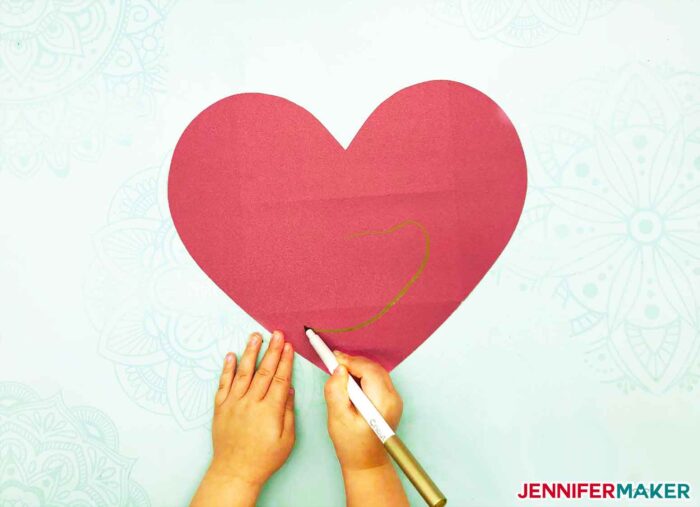 Little hands drawing a message inside the easy paper heart envelope