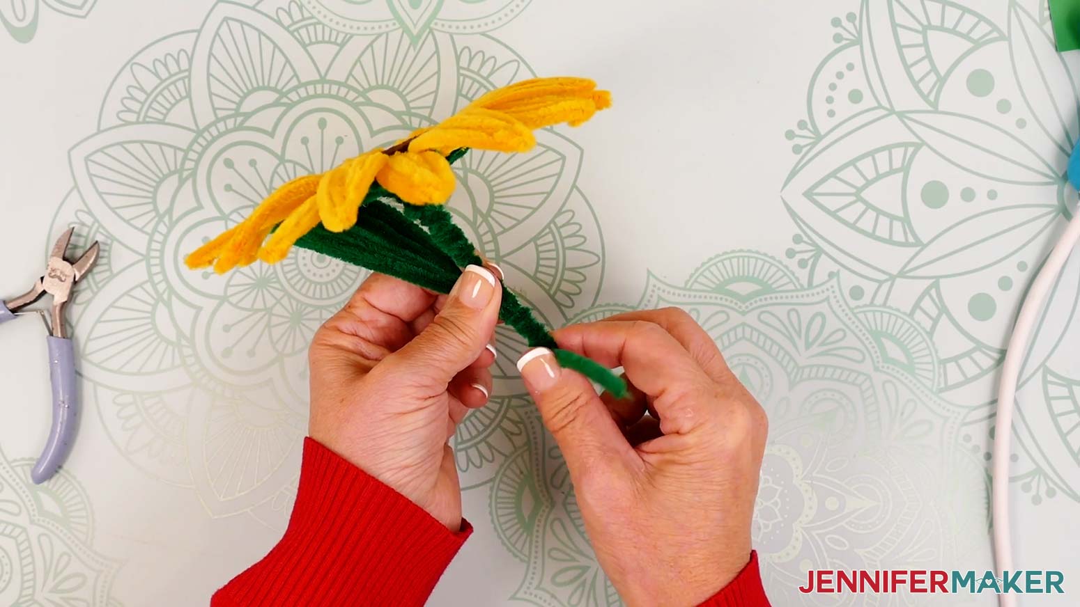 Holding the leaf in place, wrap the long pipe cleaner around the leaf’s short section and the wire stem.