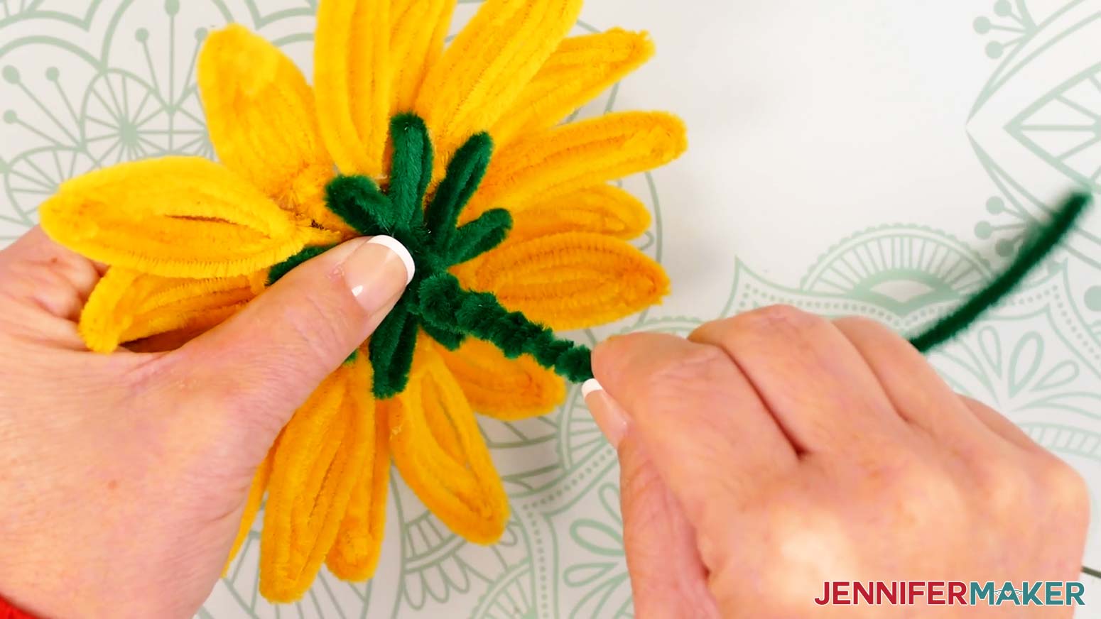 Gently push the green pipe cleaner coil up along the floral wire stem to compress it.