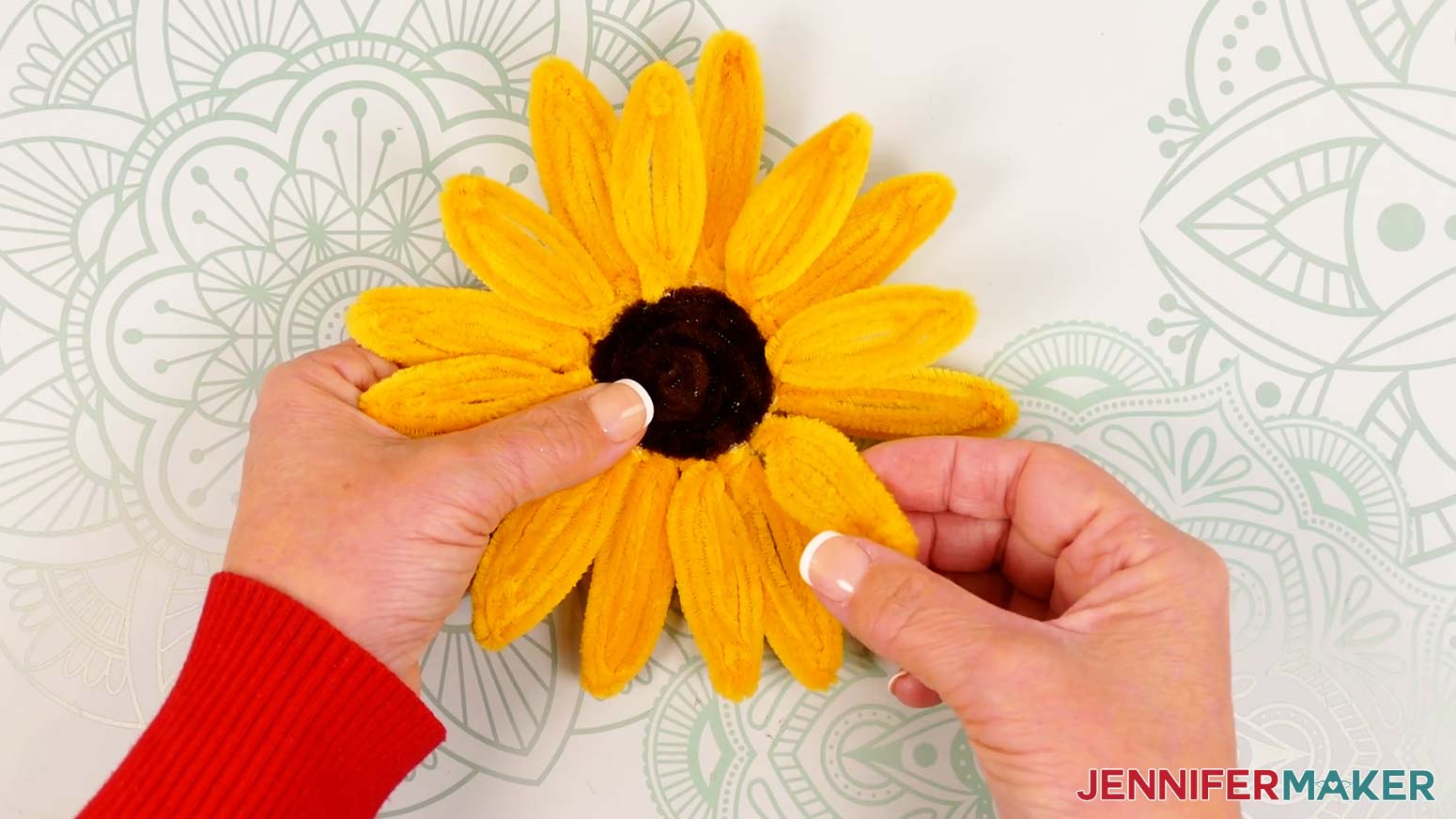 Hold the pipe cleaner sunflower face up and gently lift the first eight glued petals.