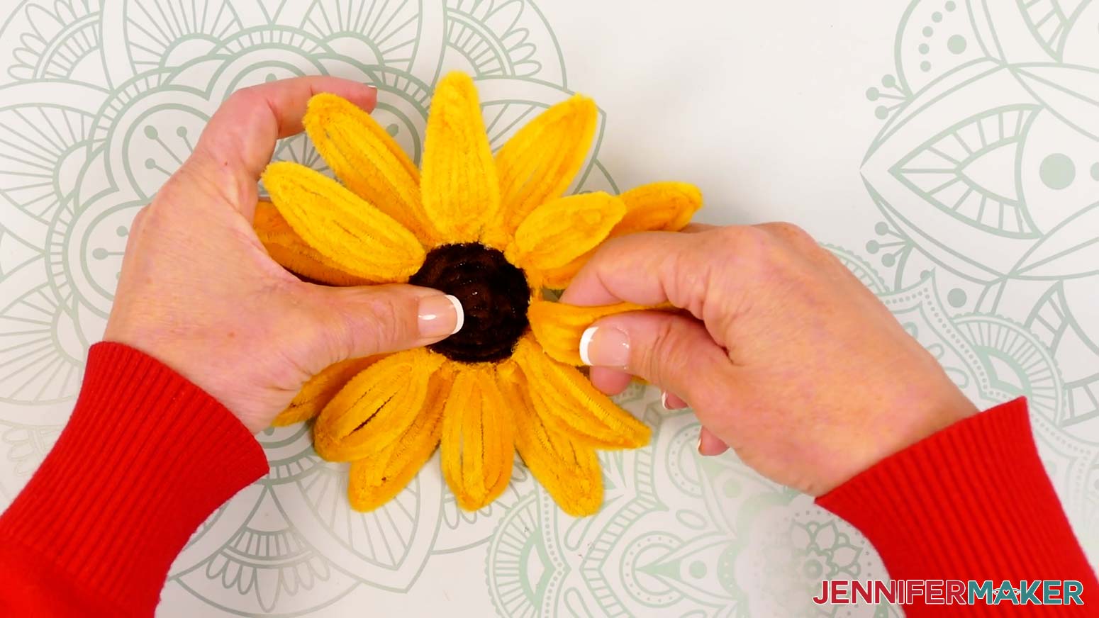 Gently curve the first eight sunflower petals around your fingers so they arch up from the center and down at the tips.