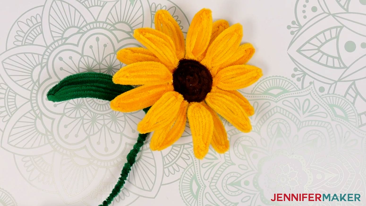 A finished large pipe cleaner sunflower lying on the work surface.