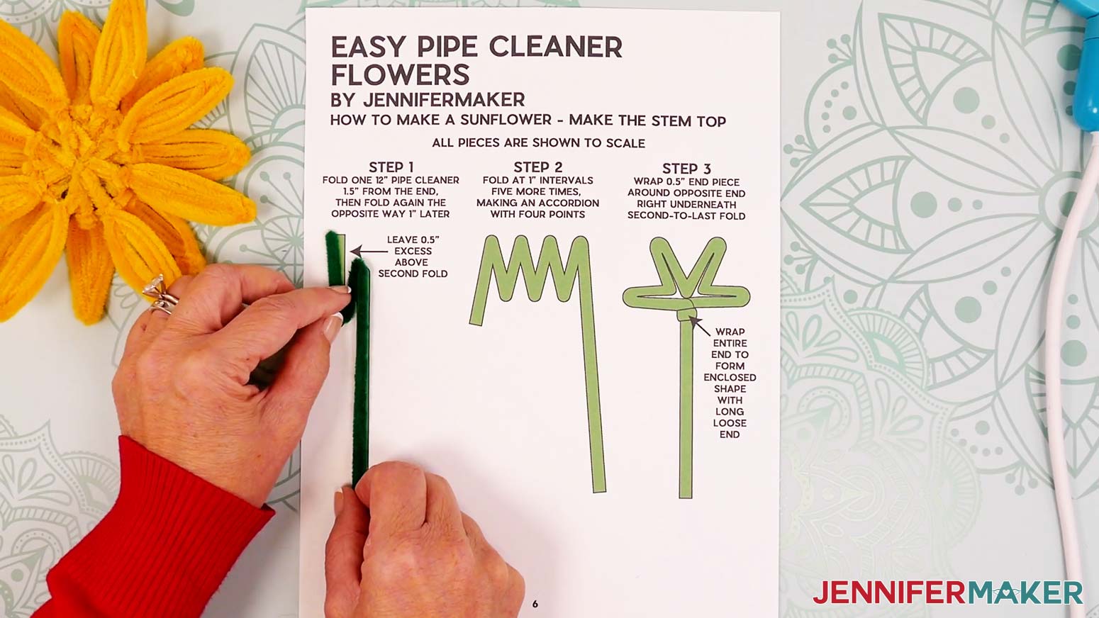 Fold the green pipe cleaner back on itself in the opposite direction to make an accordion shape.