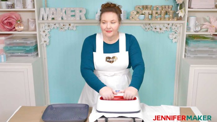 Jennifer using the Cricut EasyPress 2 to press a black tote bag