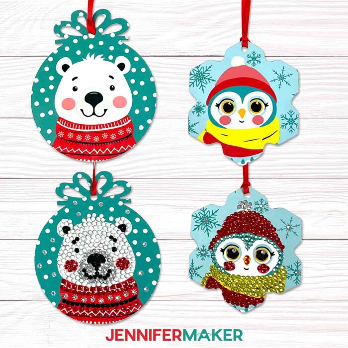 Four sublimated ornaments, two with a cute cartoon bear design and two with a cartoon penguin design. One of each of the two designs is an Embellished Ornament with jewels attached