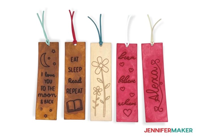 Engraved leather bookmarks with quotes and floral designs on stained backgrounds.