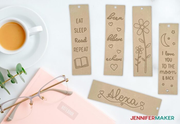 Engraved leather bookmarks with quotes and floral designs on unstained backgrounds.