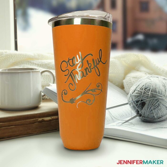 Orange metal tumbler with a decorative Stay Thankful design etched in the powder coating using Citristrip.