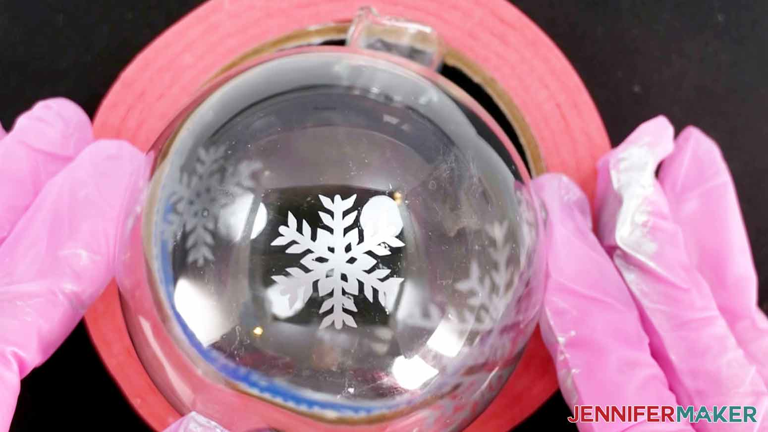 A closeup photo showing a silver colored snowflake on an etched glass ornament