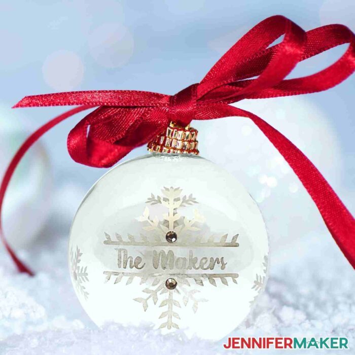 Etched glass ornament with red ribbon on top