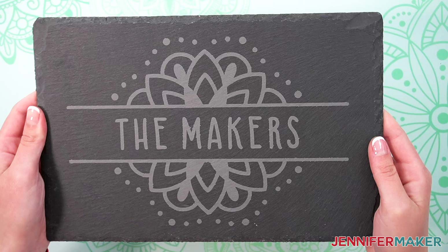 A finished etched slate cheeseboard with a mandala design and the words "The Makers" in the center.