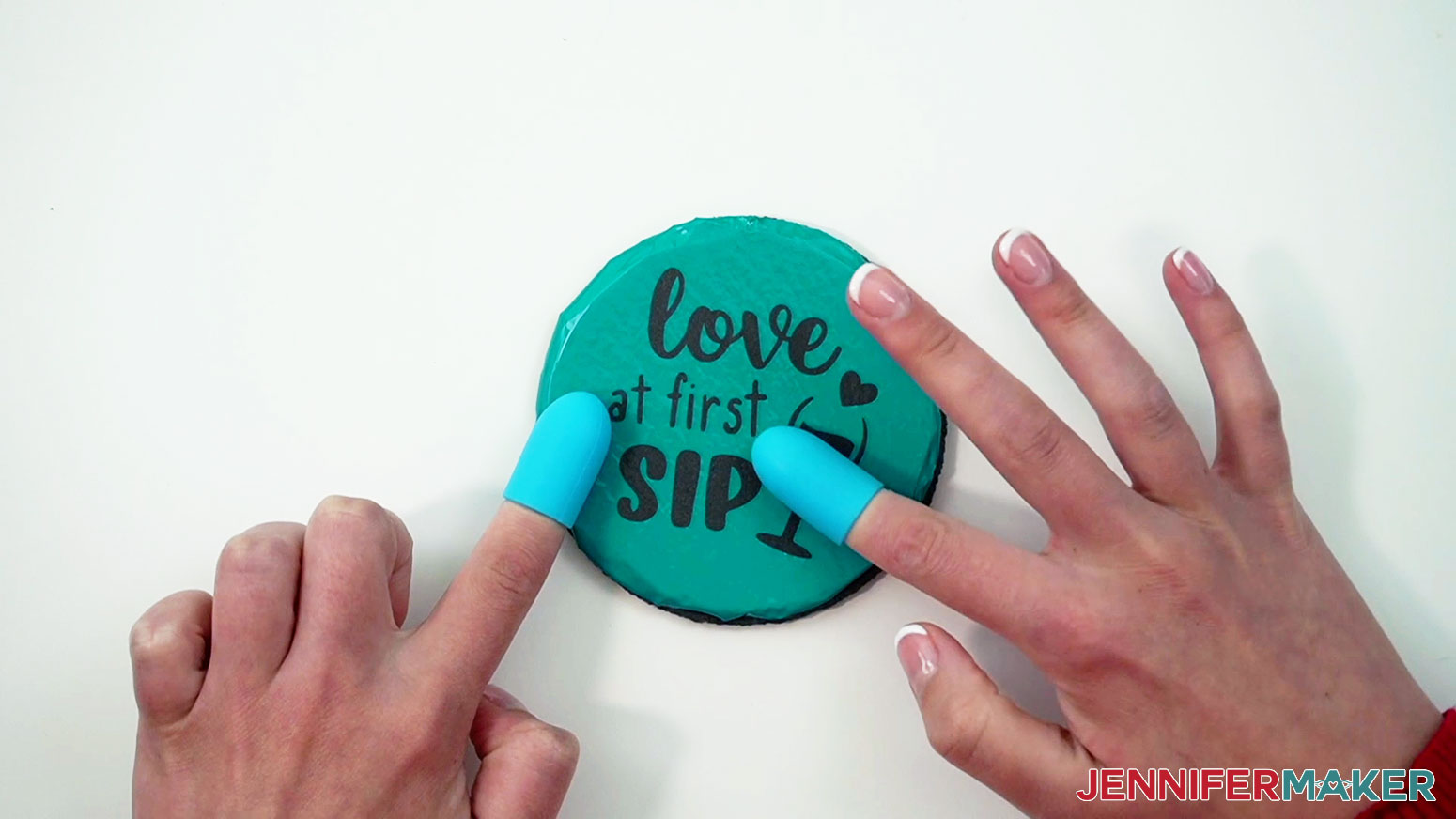 Use fingers to push the warm vinyl design down onto the slate coaster with silicone finger protectors on.