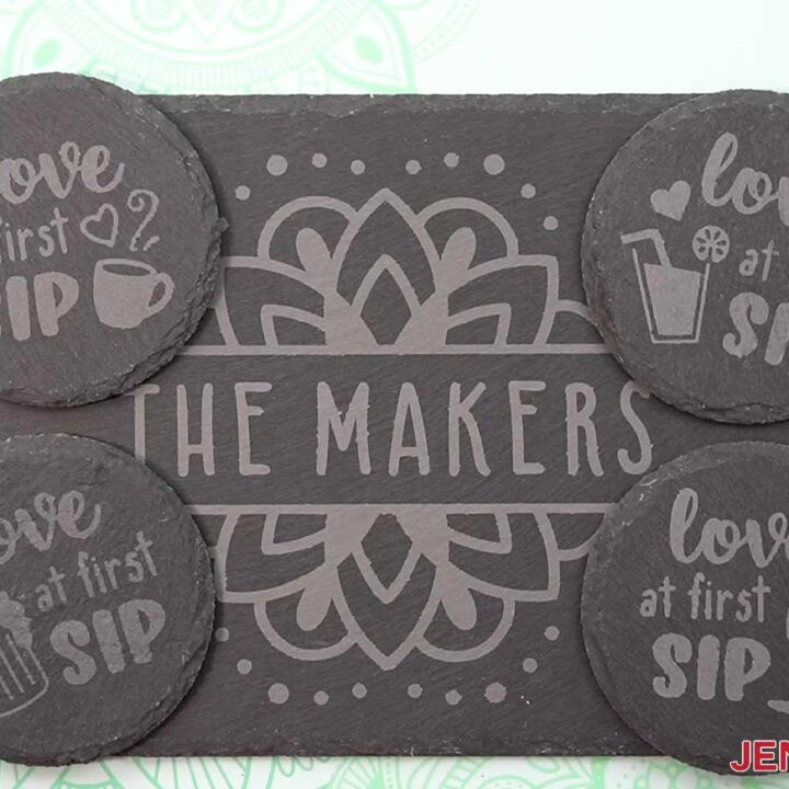 Four finished etched slate coasters displayed on top of an etched slate cheeseboard.