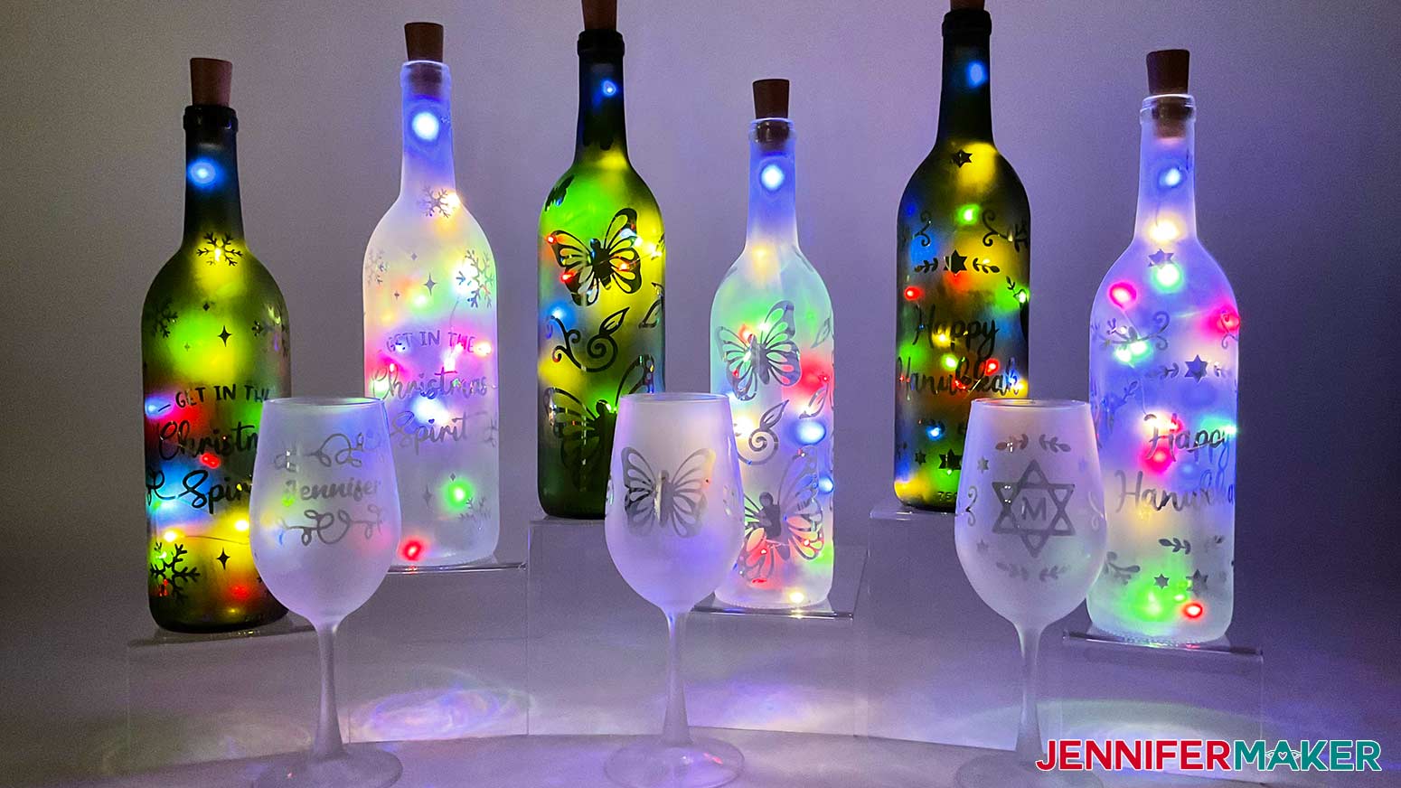 Etched wine glasses and bottles with Christmas, butterfly, and Hanukkah designs reverse etched onto them