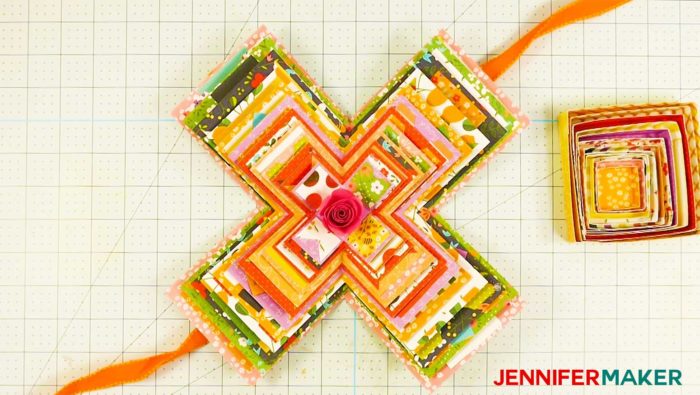 An open paper explosion box card with orange ribbon