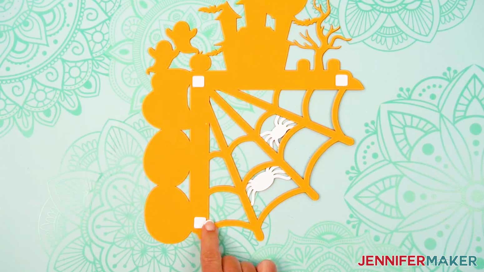 Place the foam adhesive squares on the top and bottom ends of the back of the door corner decoration.