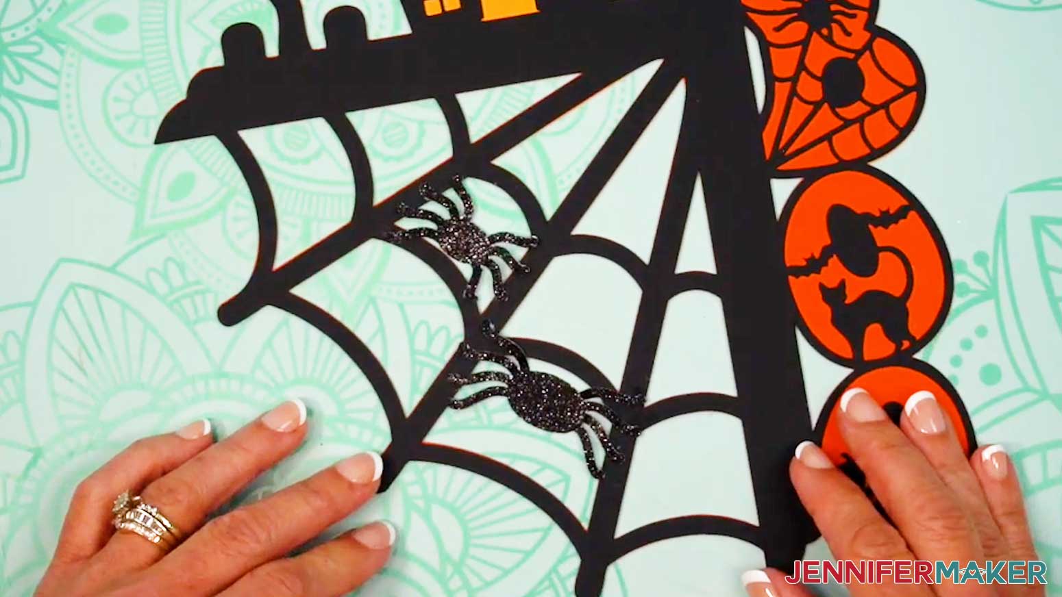 Place the spiders on the web and press them in place to adhere them to the design.