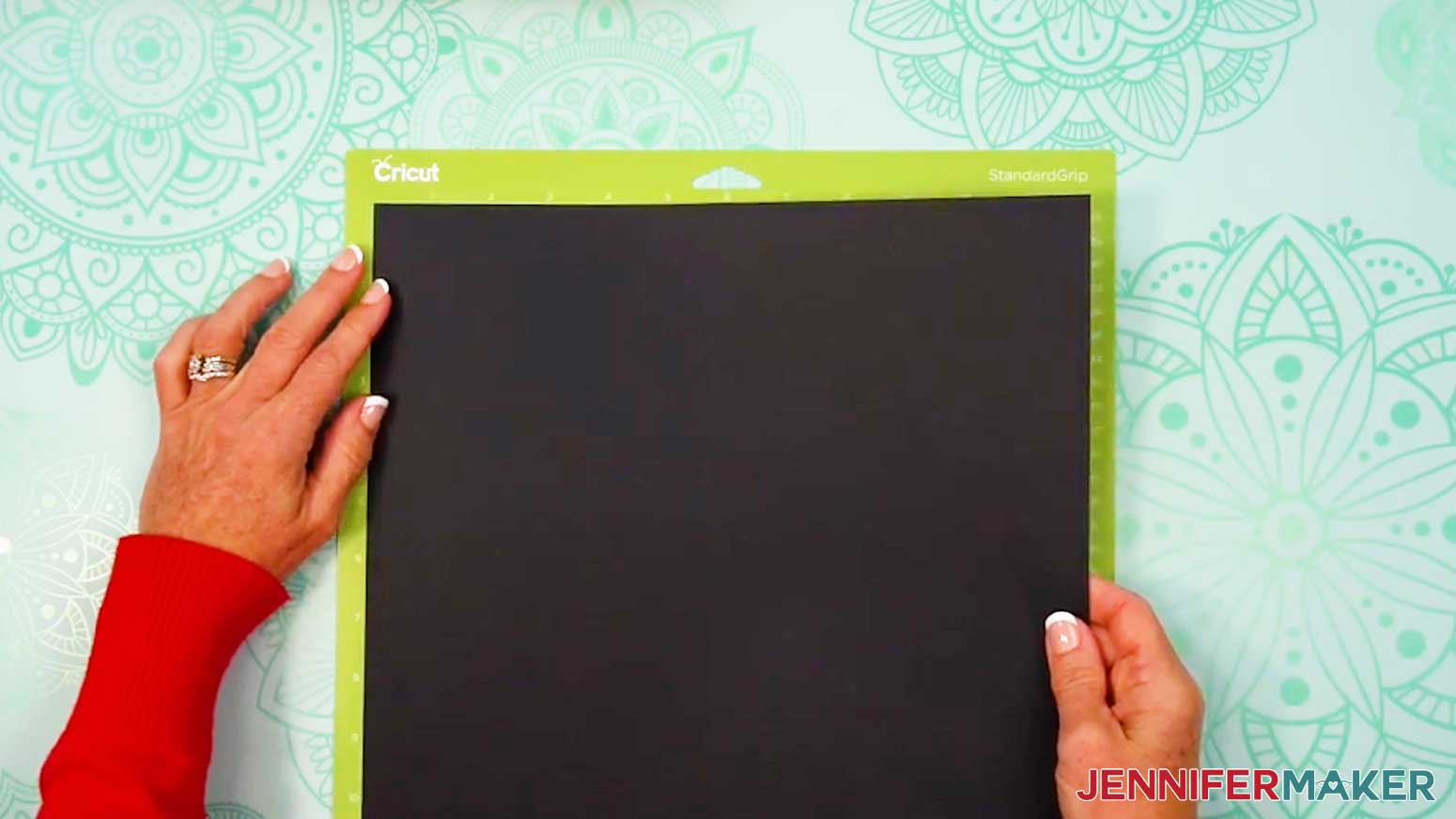 Place the black cardstock on the green machine mat.
