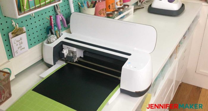 A Cricut Maker cutting black vinyl on a 24" StandardGrip mat to make a family celebration and birthday board