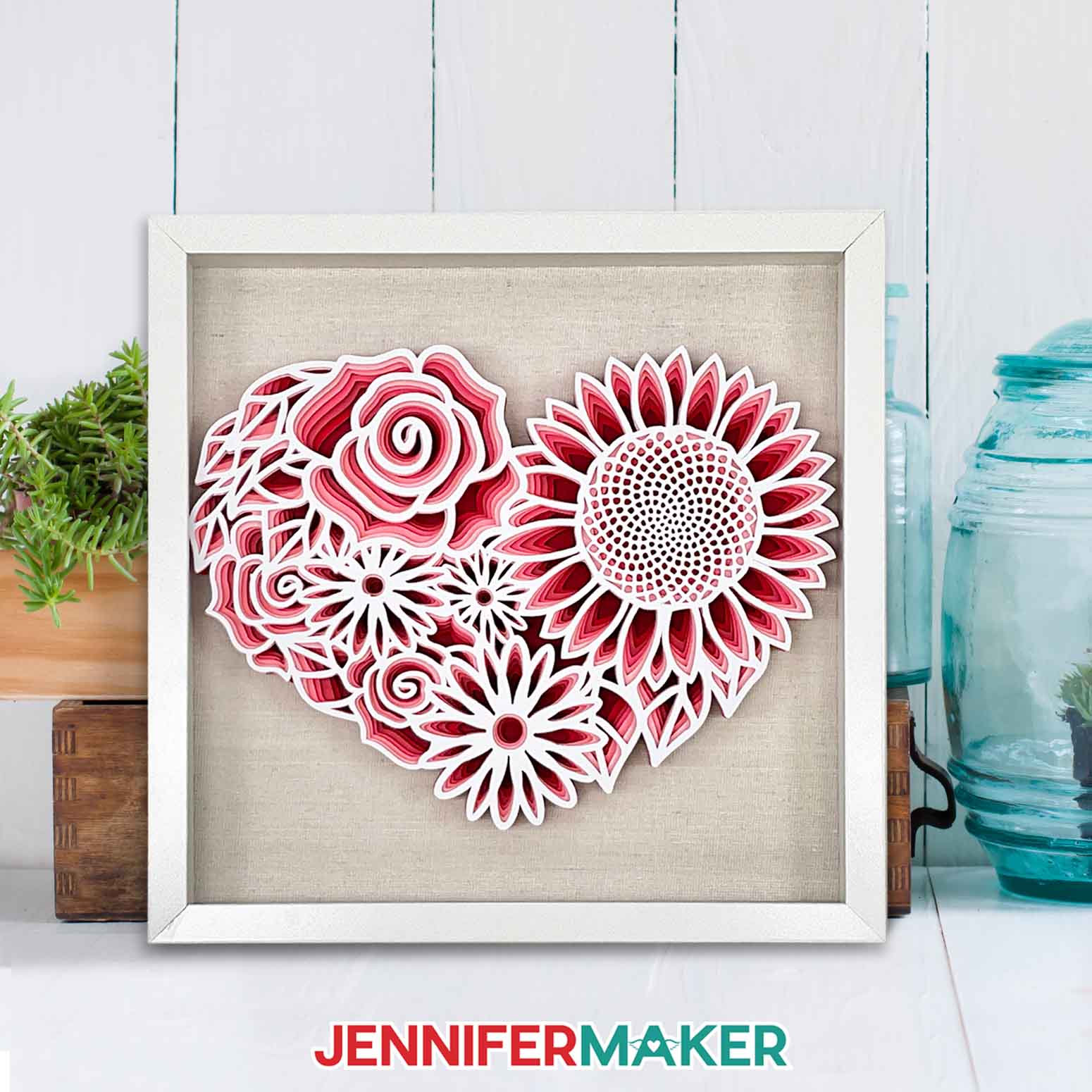 Framed layered cardstock project in shades of red and white made using a Cricut and a floral heart SVG.
