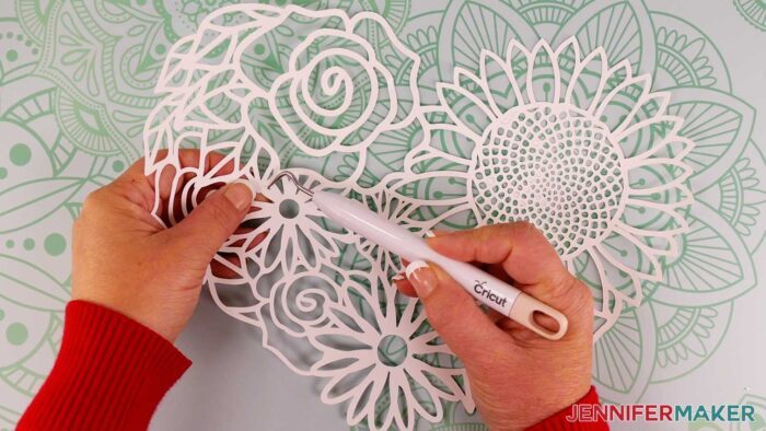 Use a weeding tool to remove small pieces of cardstock that did not stay behind when removing the cut floral heart from the mat.