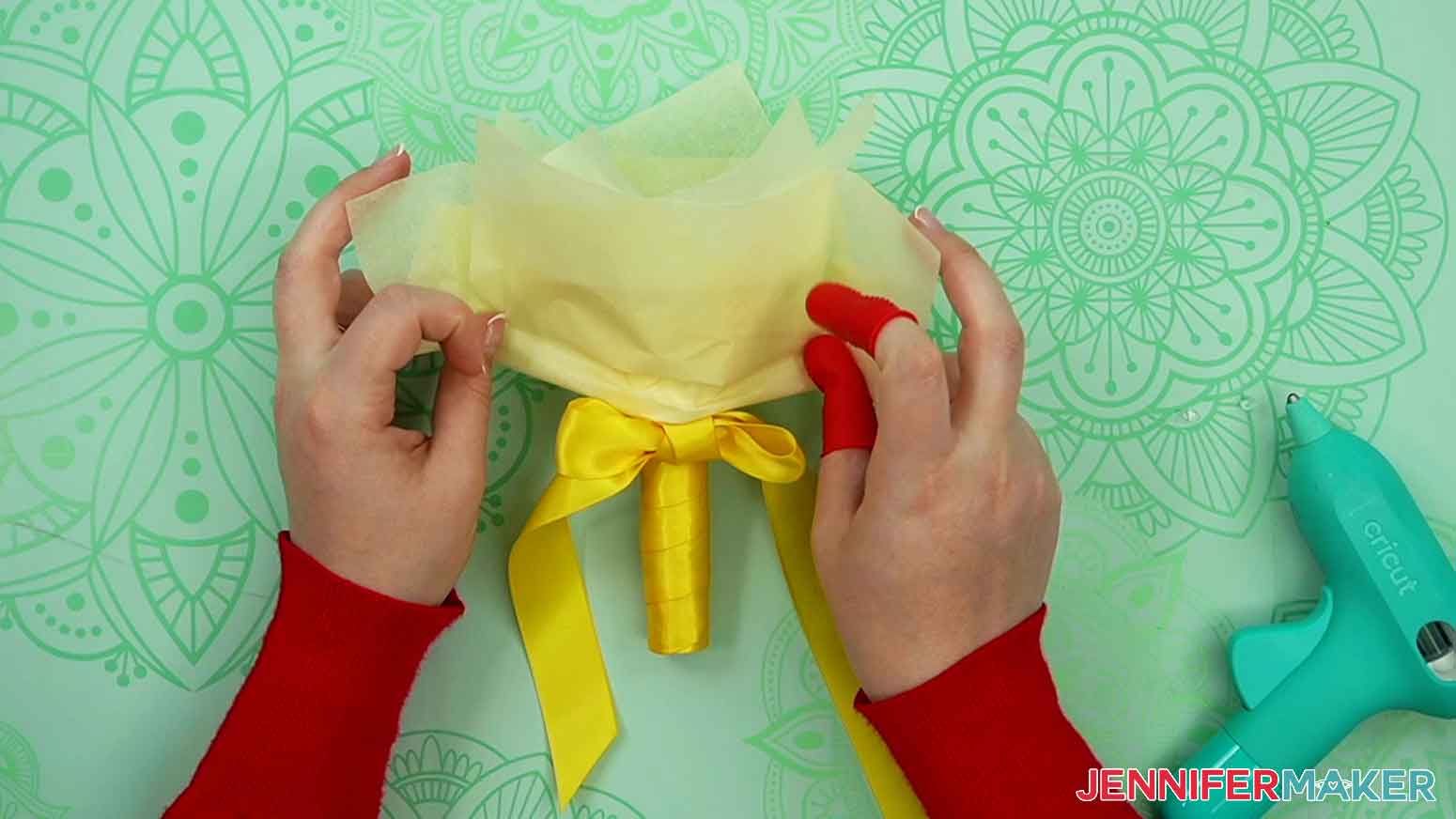 Wrap tissue paper around the cage of the handheld bouquet handle and secure it with hot glue.