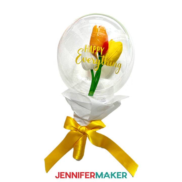 A handheld balloon bouquet with tulips inside.