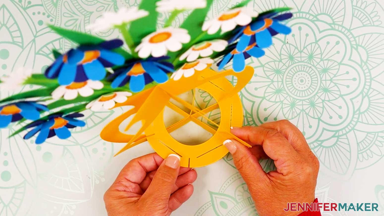 Insert the bottom base piece’s six outer slits into the three frame pieces’ bottom slits.