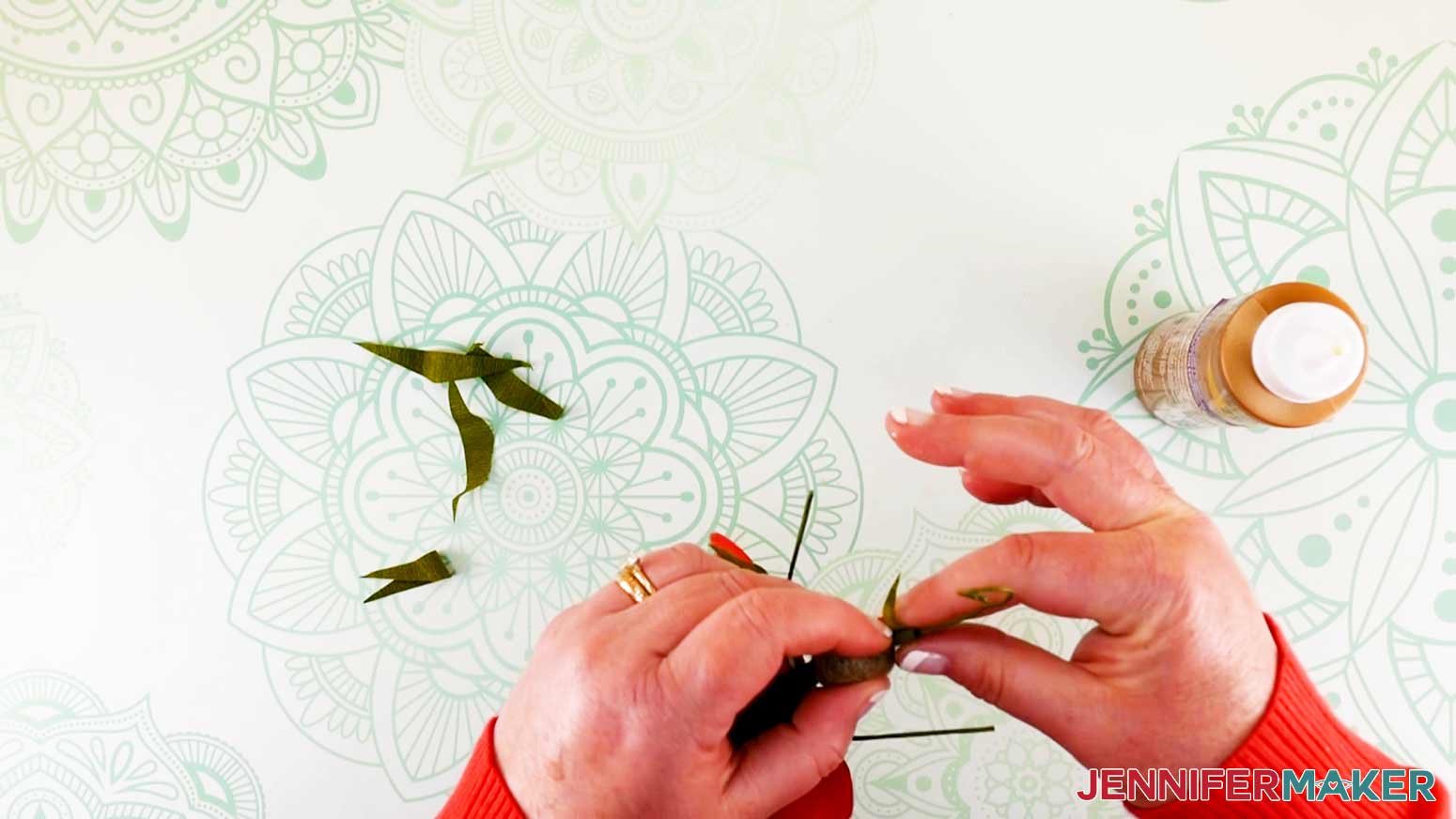 Holding head leaf in place while wrapping other end around wire of flower fairy doll