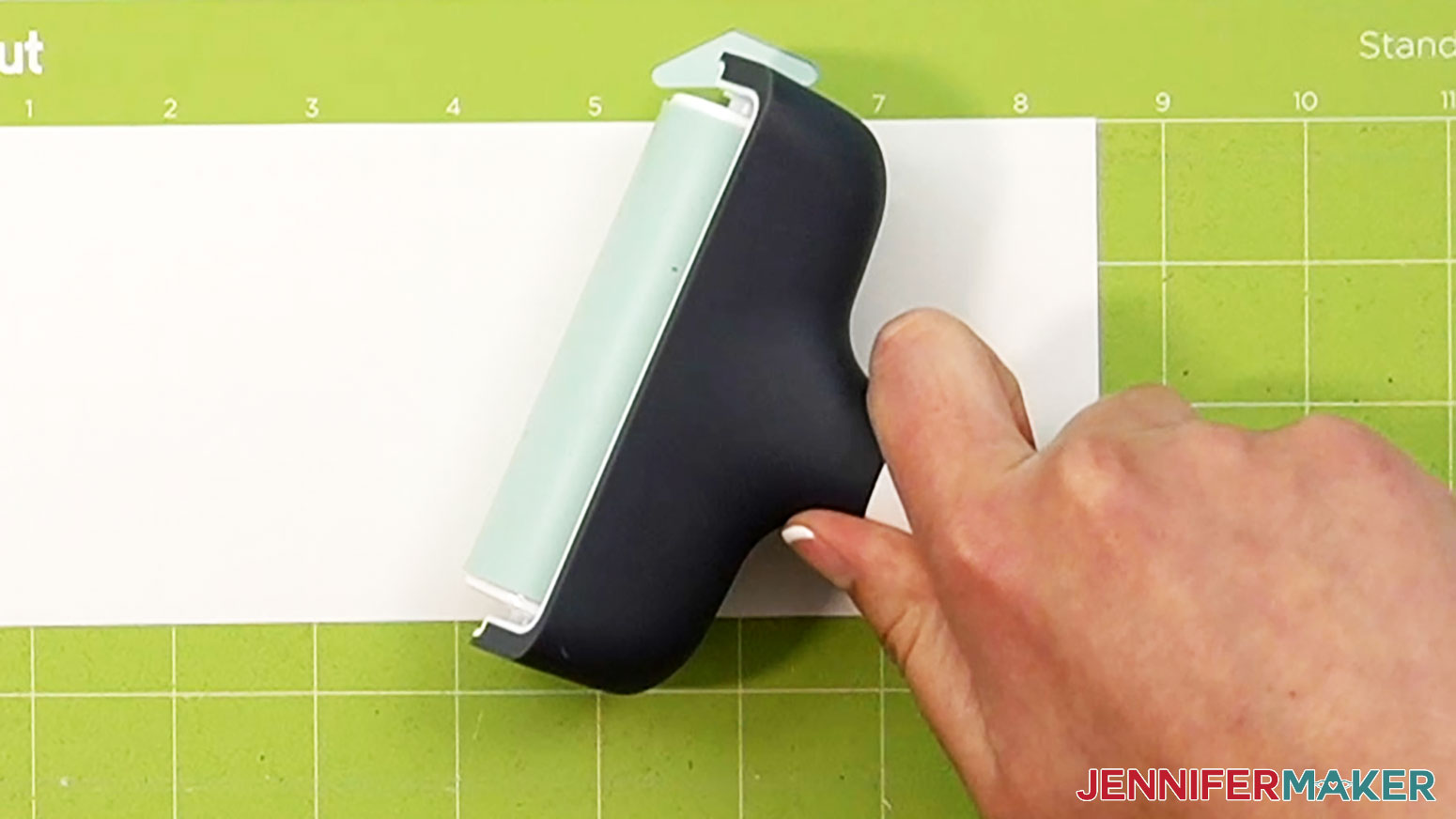 Press the vinyl firmly onto the green machine mat with a brayer.