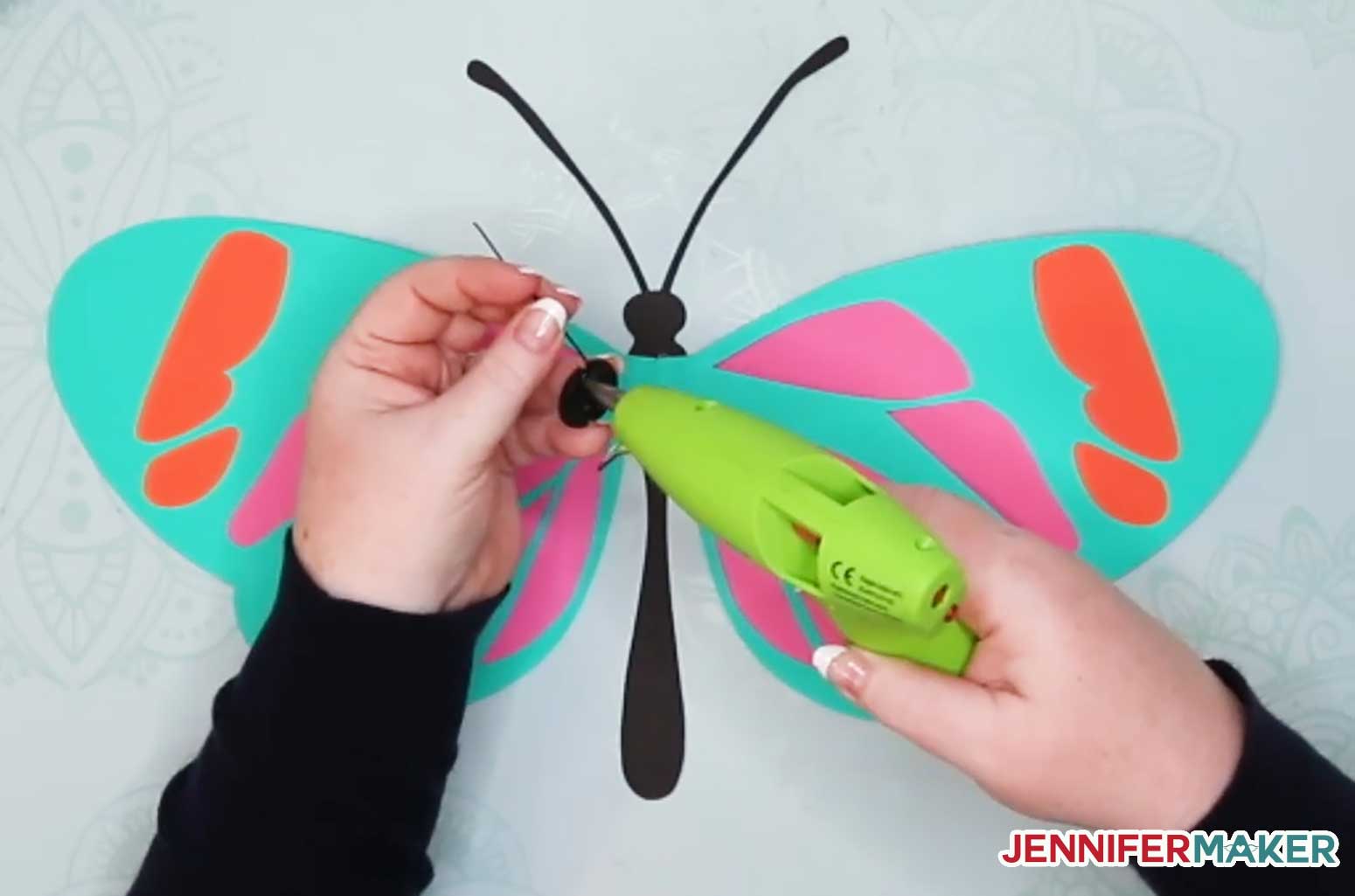 Gluing the wired circle onto the back of the giant paper butterfly