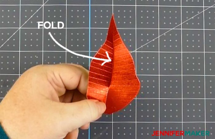 Folding a red paper poinsettia leave to make a giant paper poinsettia flower