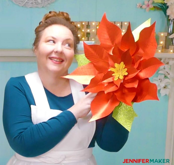 Jennifer admiring her giant paper poinsettia flower in her craft room