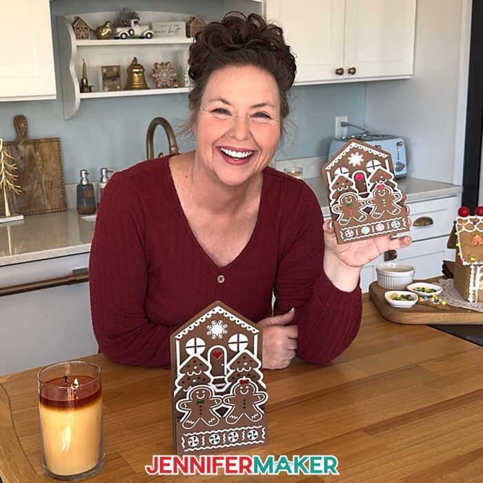 Jennifer Maker sits in her kitchen, showing off some Gingerbread House Pop-Up Card projects