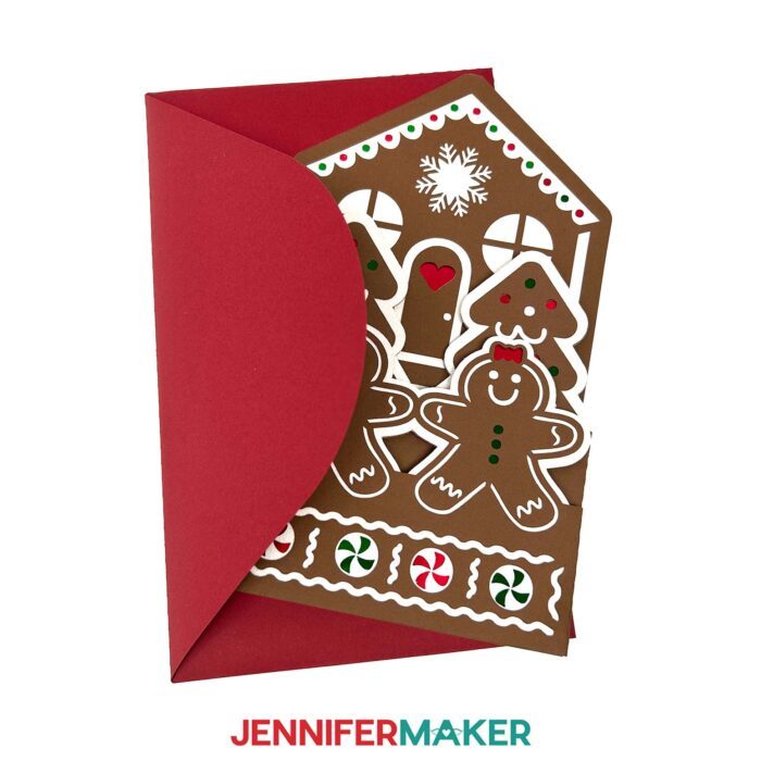 A brown Gingerbread House Pop-Up Card sits on display, with red, green, and white details, little "cookie" people, and a red envelope for mailing