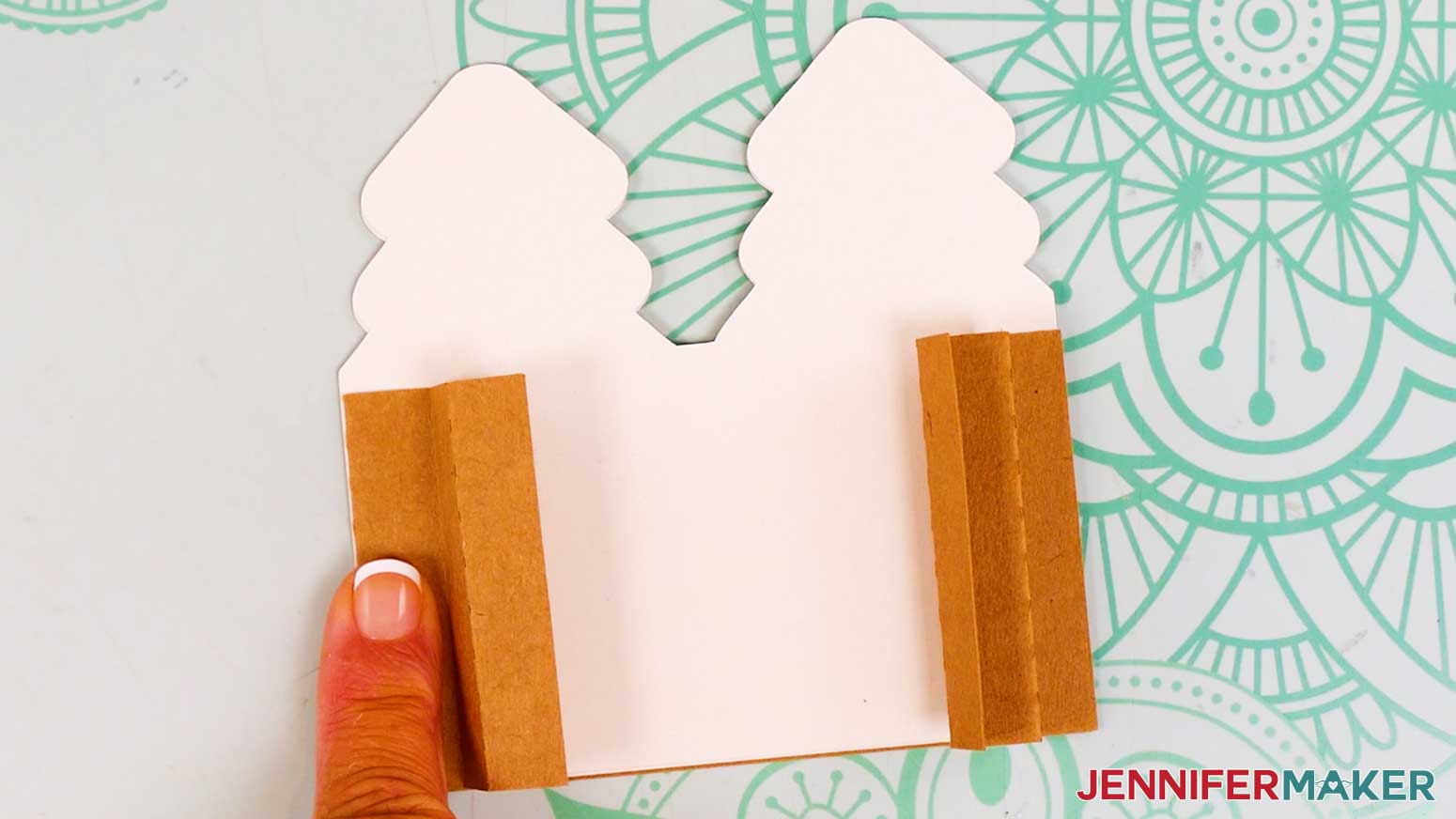 The right accordion fold is in place and the left accordion fold is being adhered on the left side of the joy sized card.