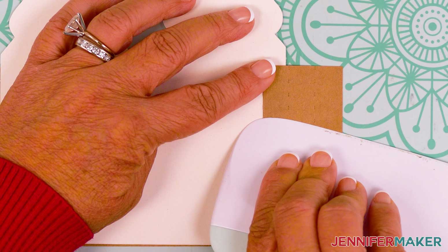 Using a scraper to create the second fold inward on the tree tier of the gingerbread card
