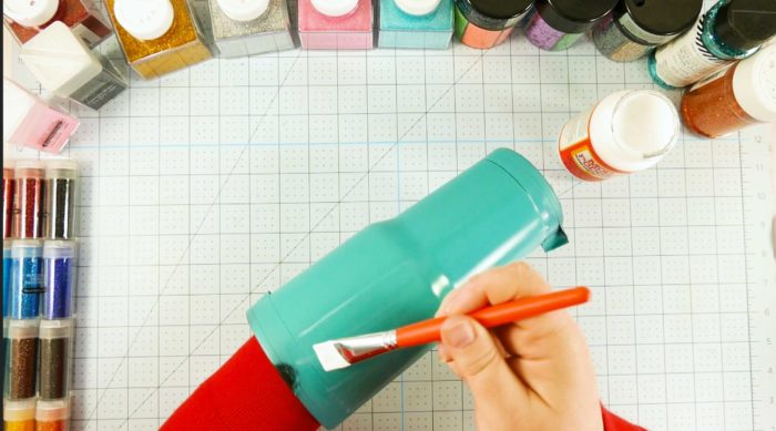 Brushing on Mod Podge onto a painted tumbler is step 3 of the glitter tumbler tutorial