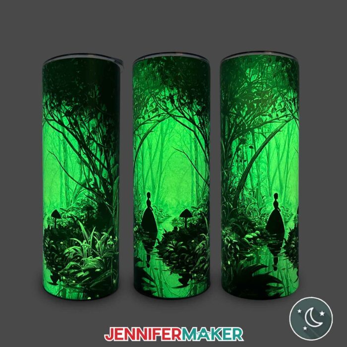 Three views of a Glow In The Dark Tumbler With Reverse Sublimation design of a woman in a spooky, enchanted forest