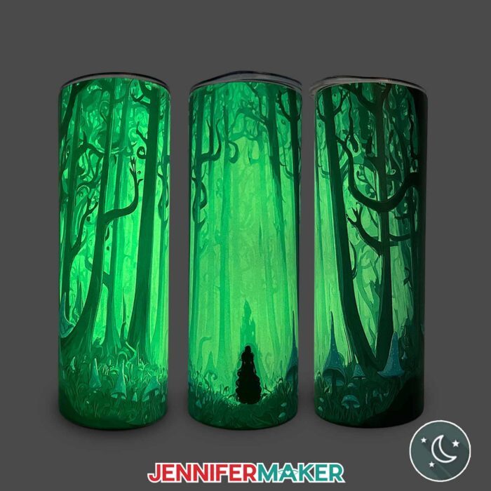 Three views of a Glow In The Dark Tumbler With Reverse Sublimation design of a woman in a spooky, enchanted forest