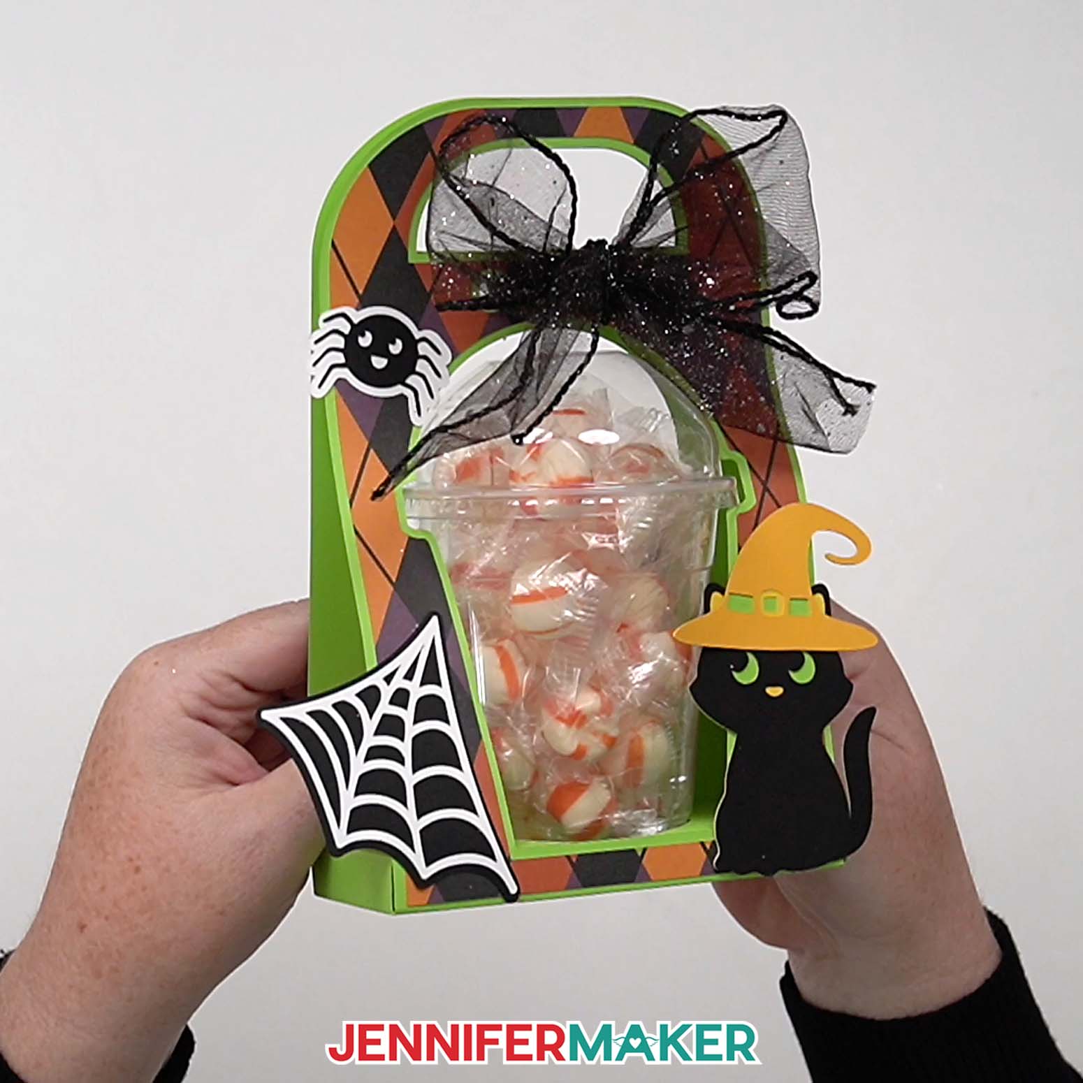 A complete Halloween treat cup holder is held and ready for gift giving.