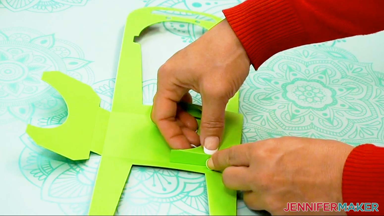 Bend the outside flap into the center of the base assembly of the Halloween treat cup holder to begin creating the cup pocket area.