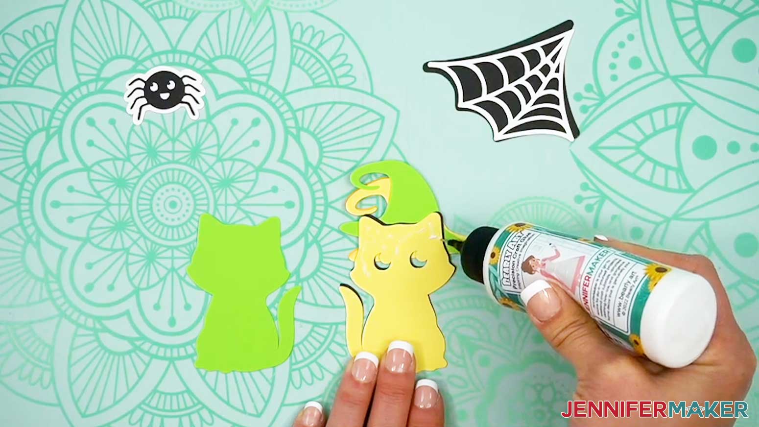 Place glue on the back of the second layer of the Halloween treat cup holder cat embellishment before applying it to the final back piece.