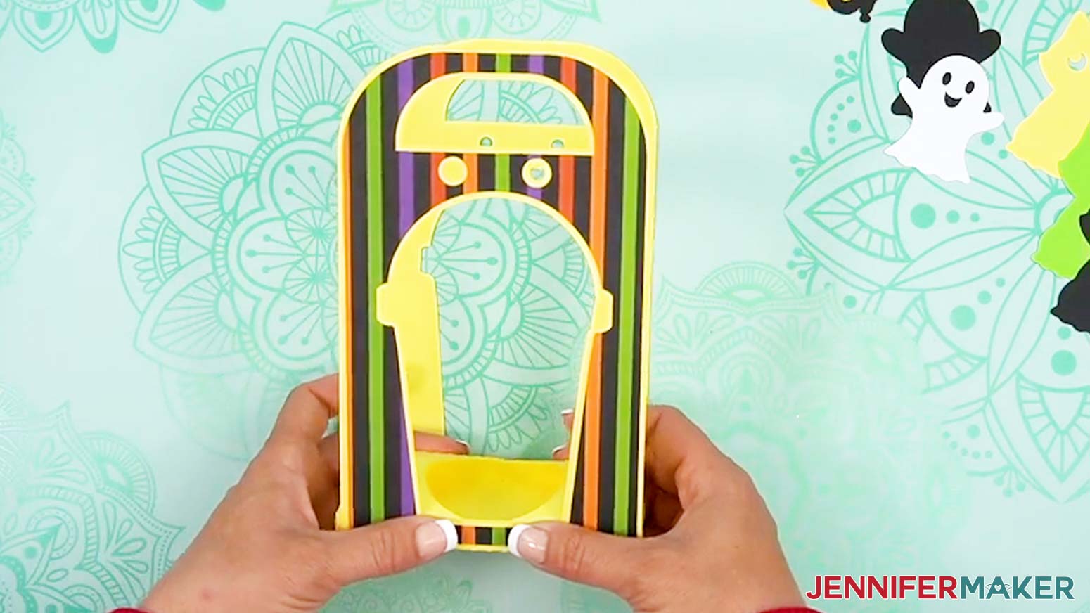 Hold the assembled Halloween treat cup holder together while the glue sets.