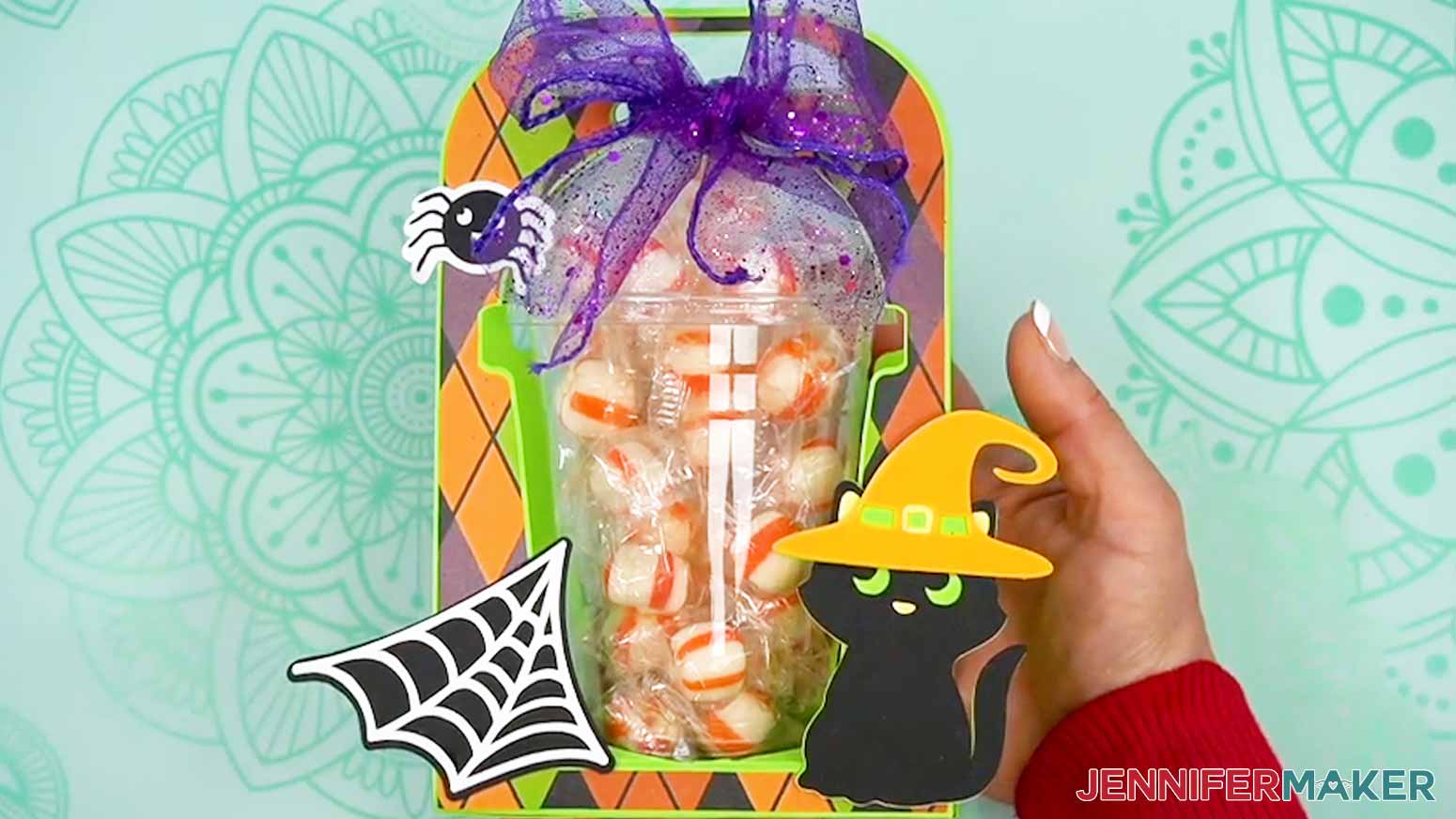Carefully slide a filled cup into the back of the Halloween treat cup holder.