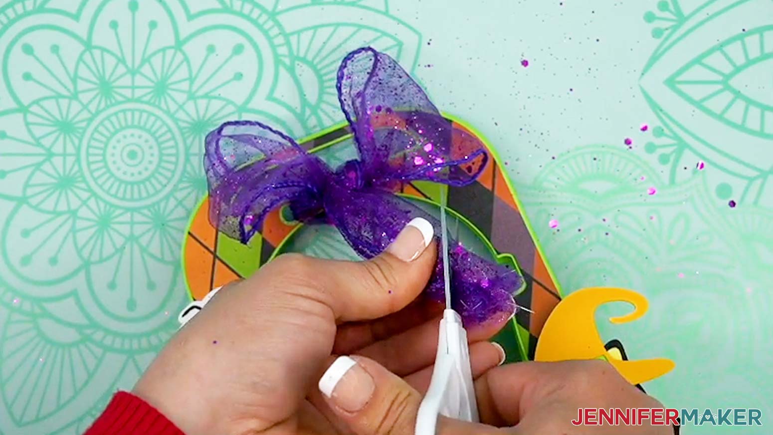 Lay the edges of the ribbon together and trim them evenly after tying the Halloween treat cup holder closed.