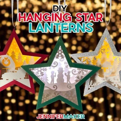 Make DIY Hanging Star Lanterns with JenniferMaker's tutorial! Three miniature star-shaped layered cardstock ornaments with winter and holiday scenes inside, hanging on a backdrop of twinkling Christmas lights.
